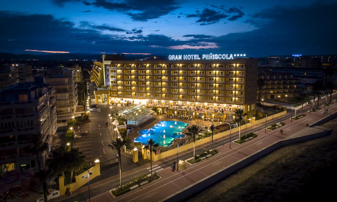 Hotel con la fachada y la piscina ilumindas al anochecer